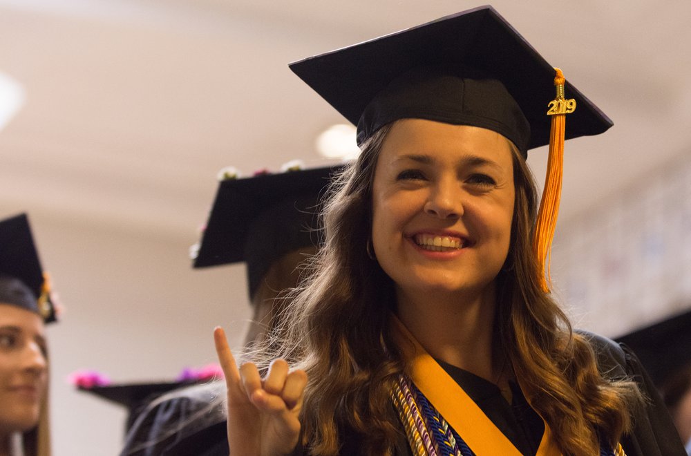 Student giving stingers up gesture at Commencement