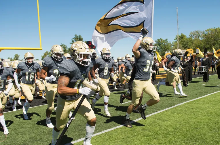 Football players running across field
