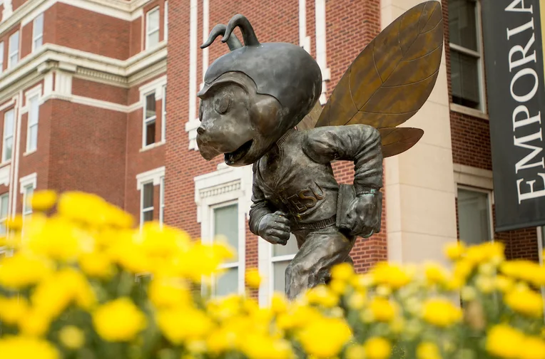 Corky statue surrounded by flowers