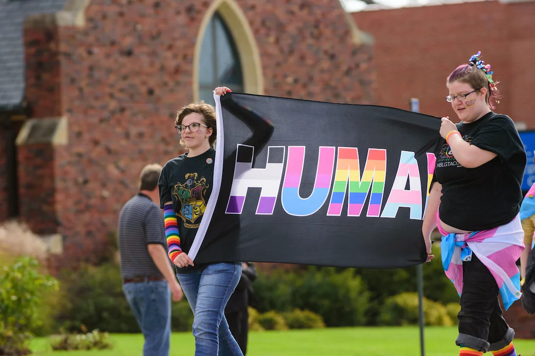 Students displaying PRIDE flag