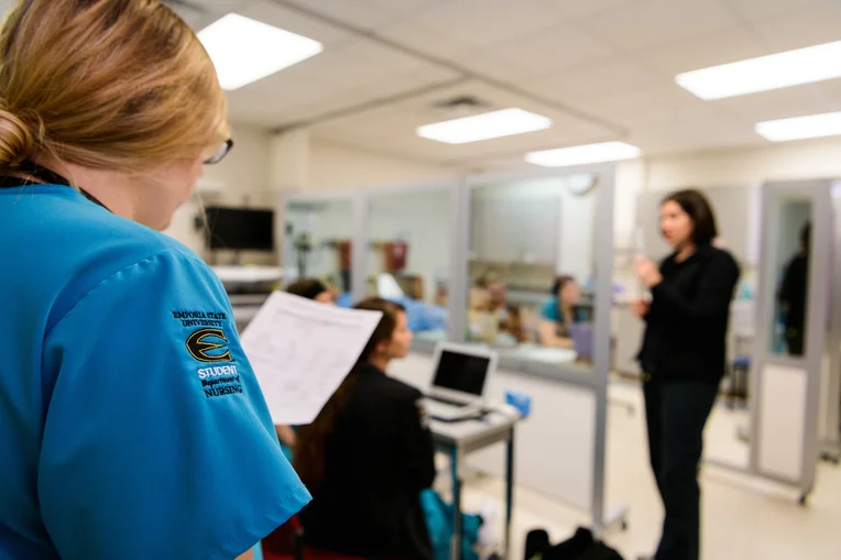 Nursing student reviewing notes during lecture