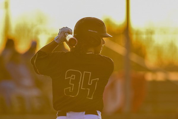 Emporia State University Baseball player swinging bat