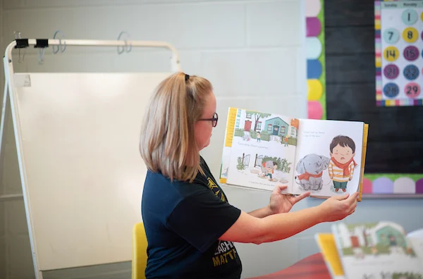 Elementary teacher reading books to students