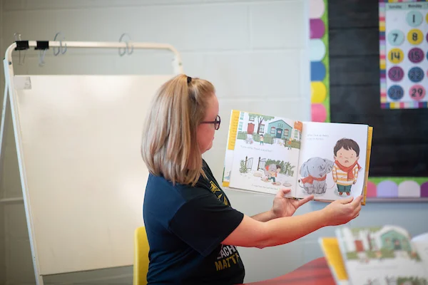 Elementary teacher reading books to students