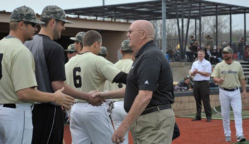 Jerry Smith shakes hands with Hornet baseball players after throwing out the first pitch April 11 during a ceremony to honor his longtime friend, the late Larry Wild. 