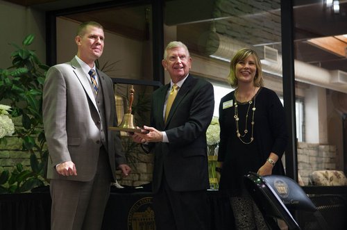 Gary Sherrer, center, accepts a ceremonial bell from Shane Shivley, vice president of development for the Emporia State Foundation, and Jennifer Denton, vice president of stewardship and administration for the Foundation.  