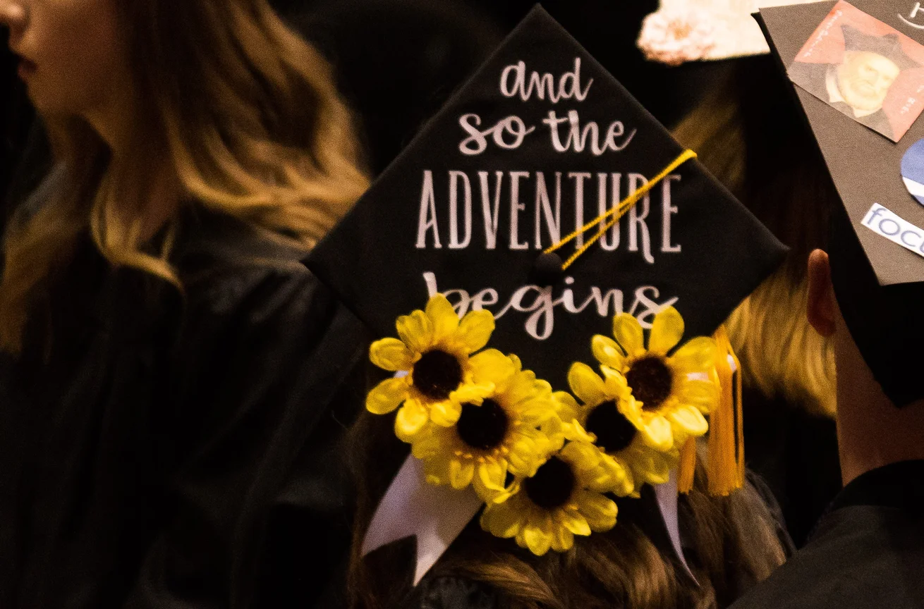 Graduation Cap with the words "and so the adventure begins"