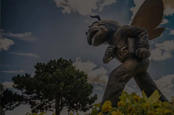 Bronze statue of Corky with flowers