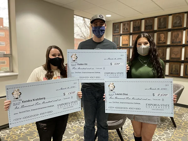 Emporia State students posing with giant checks