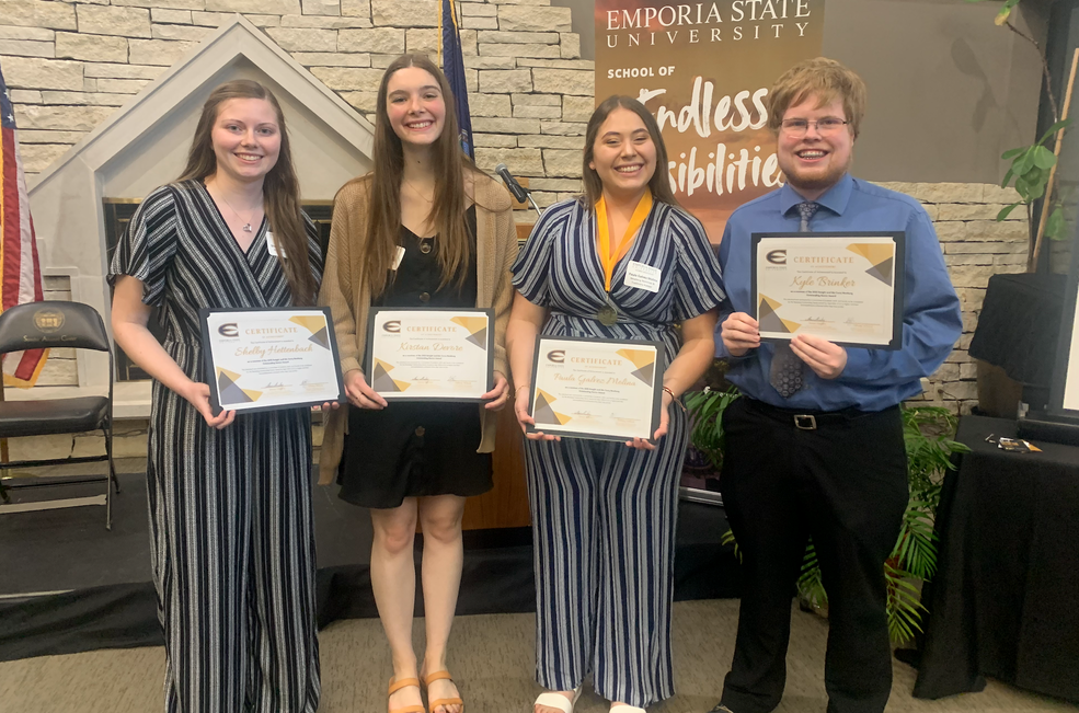 Four students are holding a certificate.