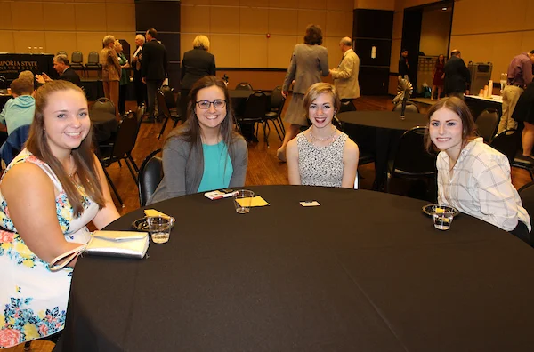 Emporia State students sitting at table smiling