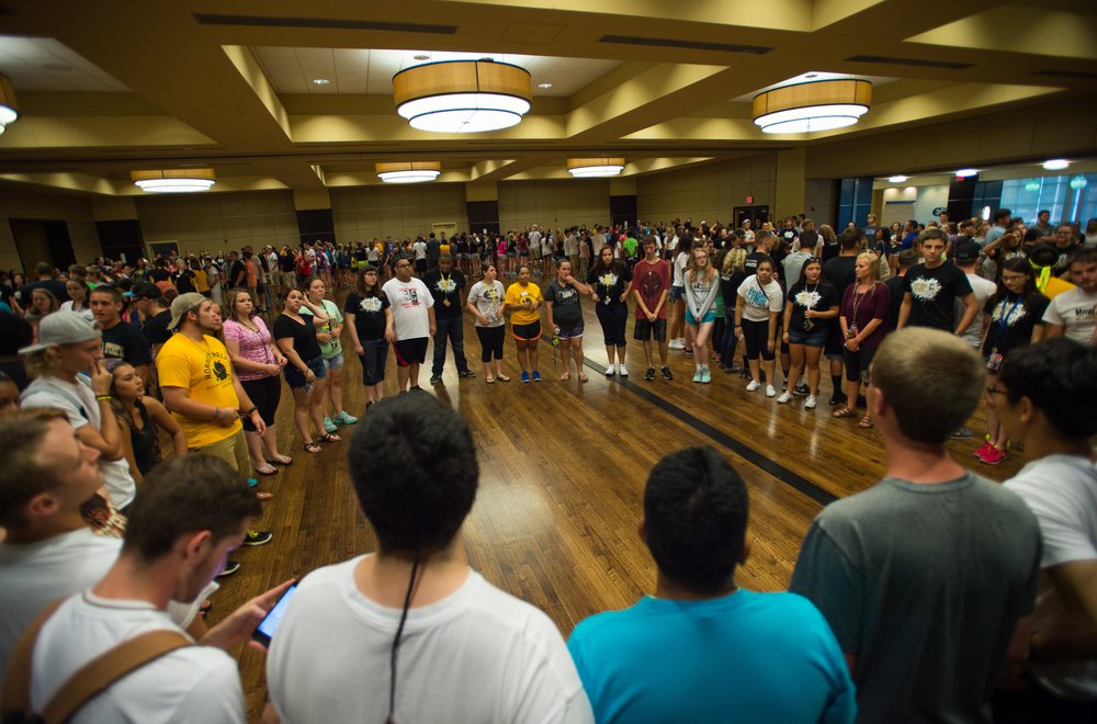 Emporia State students standing in circle performing group activity