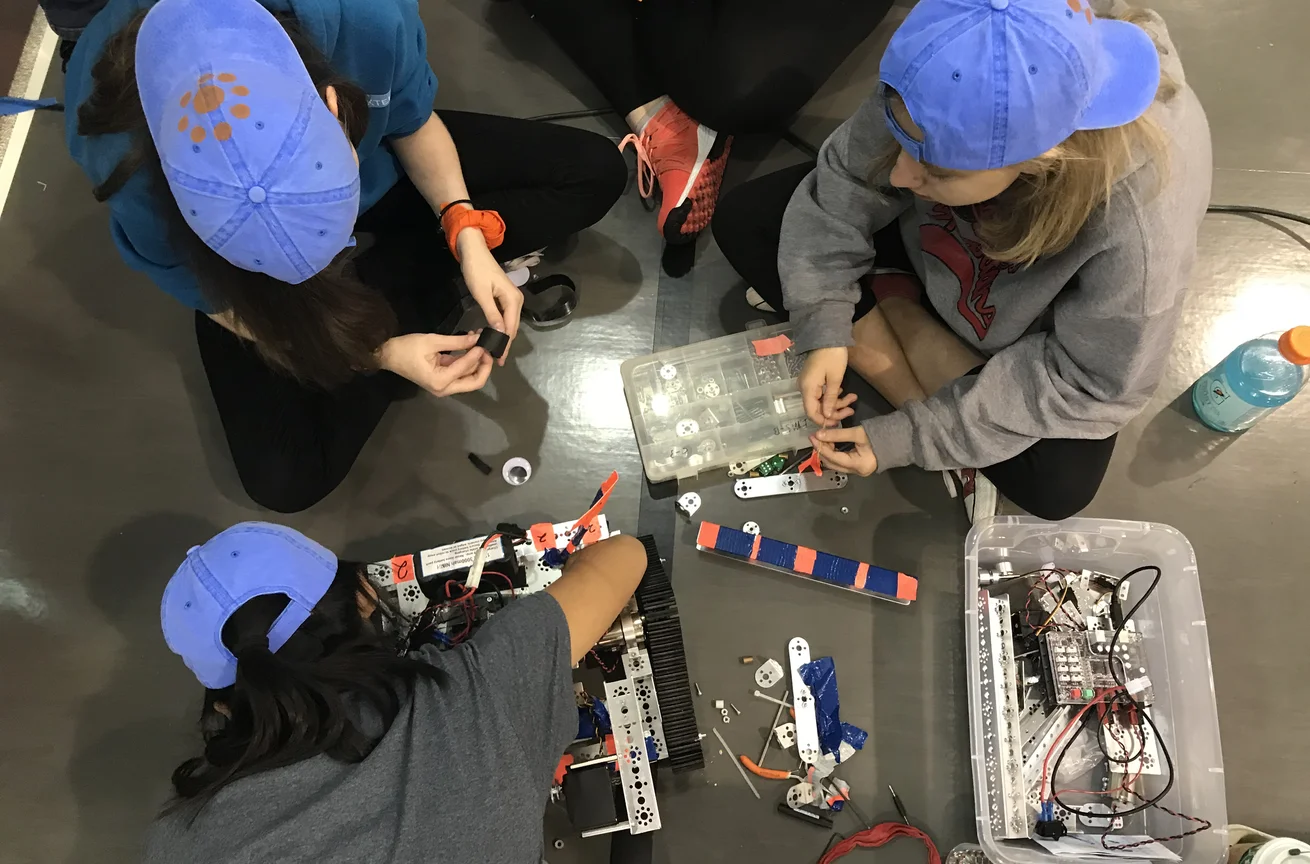 middle school students working with robotics kit