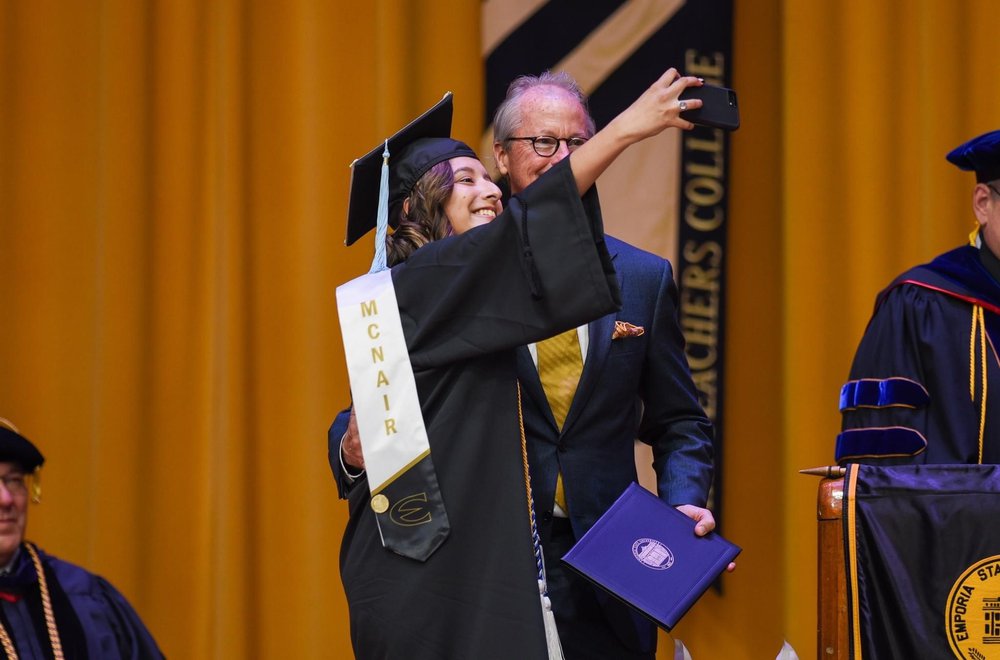 McNair Scholar graduate poses for photo with Emporia State University president Ken Hush at Commencement