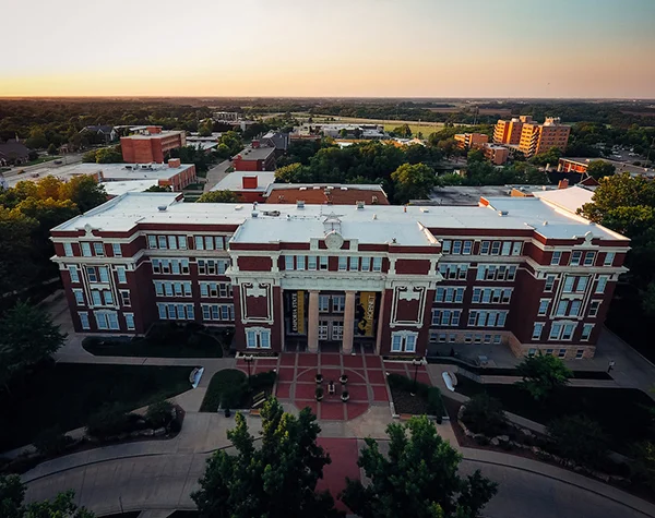 An aerial photo of Emporia State University focuses on a brick building with white columns.