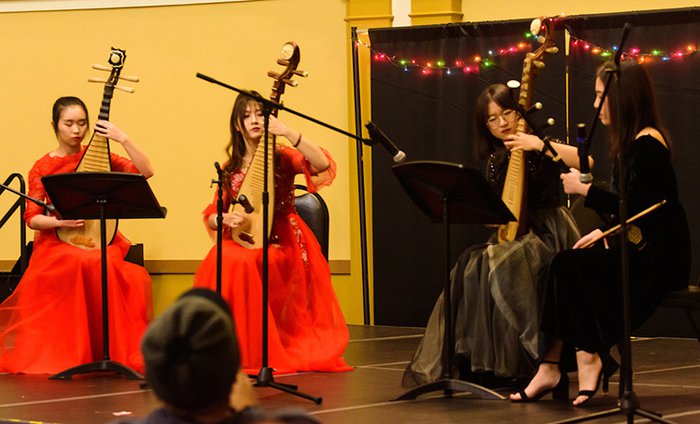 Four students play musical instruments.