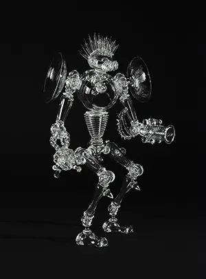 A clear glass sculpture that looks like a robot with a spiked mohawk
