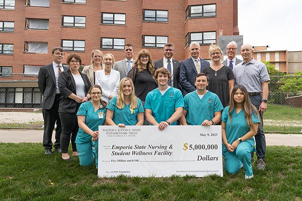Officials from Emporia State University and the Walter S. & Evan C. Testamentary Trust, Bank of America, N.A., Trustee gather behind ESU nursing students during a check presentation on campus.