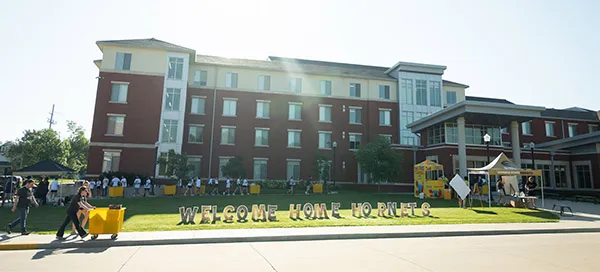 External view of residence hall with sign in front: Welcome Home, Hornets